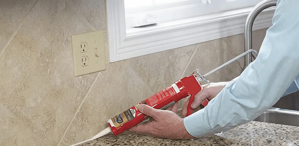 Handyman applying caulk along a kitchen backsplash and countertop seam in San Francisco, CA